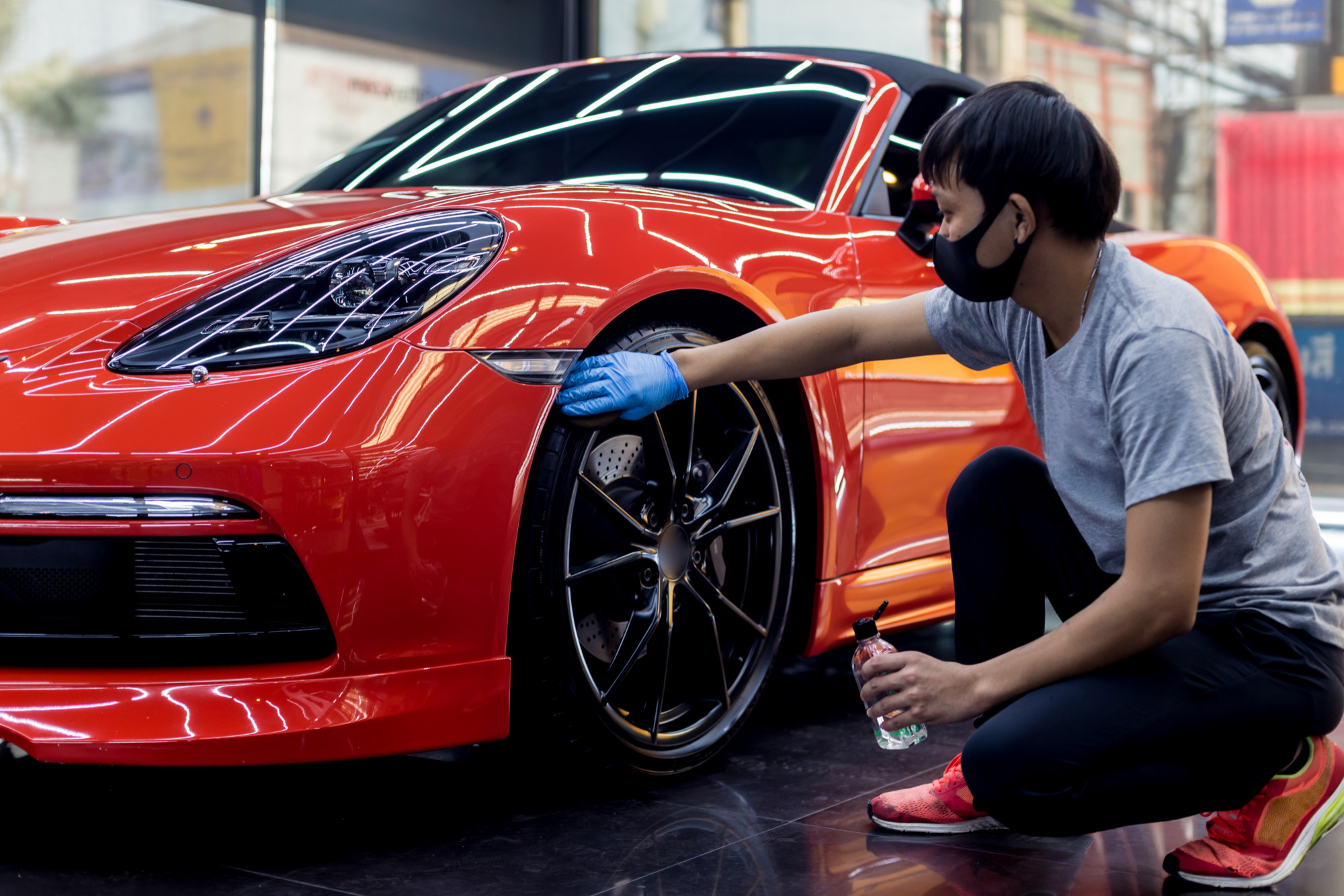 car-service-worker-polishing-car-wheels-with-microfiber-cloth